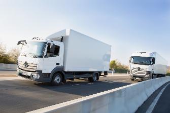 
Dwa samochody ciężarowe podlegające opłatom drogowym jadą autostradą jeden za drugim.